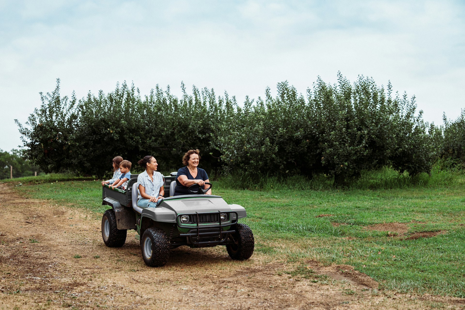 Due donne guidano una jeep decappottabile, con due bambini che si affacciano da quello